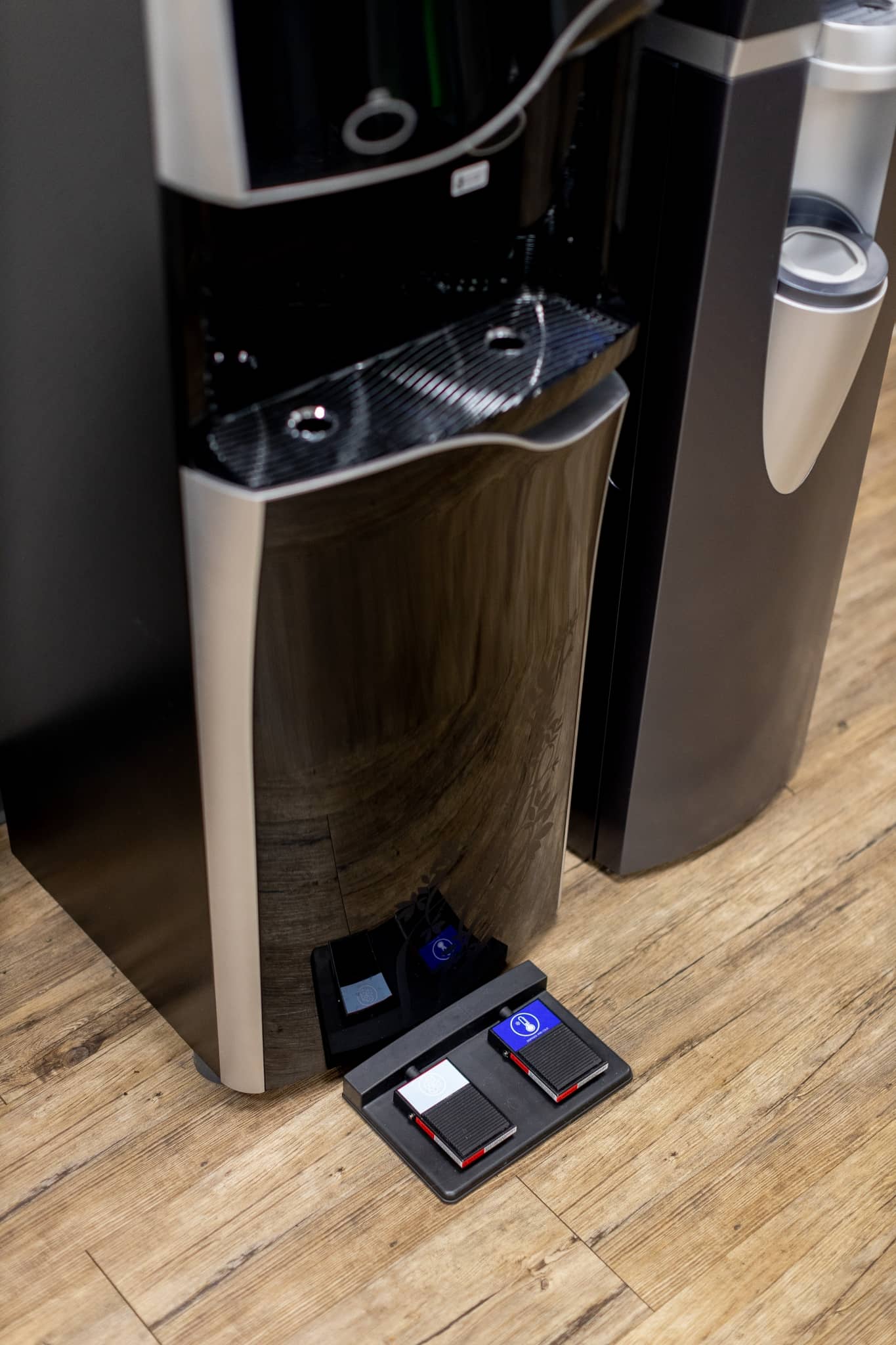 A black water cooler with foot pedals.