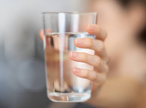 A woman holding a glass of water