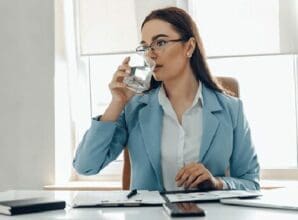 woman drinking water at desk